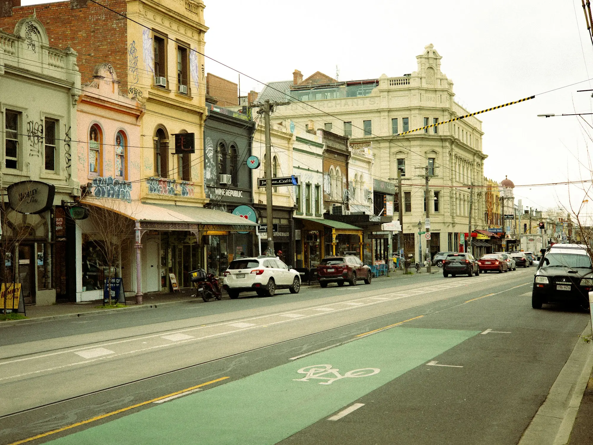 Two-storey commercial building with shopfronts on a tree-lined Adelaide street
