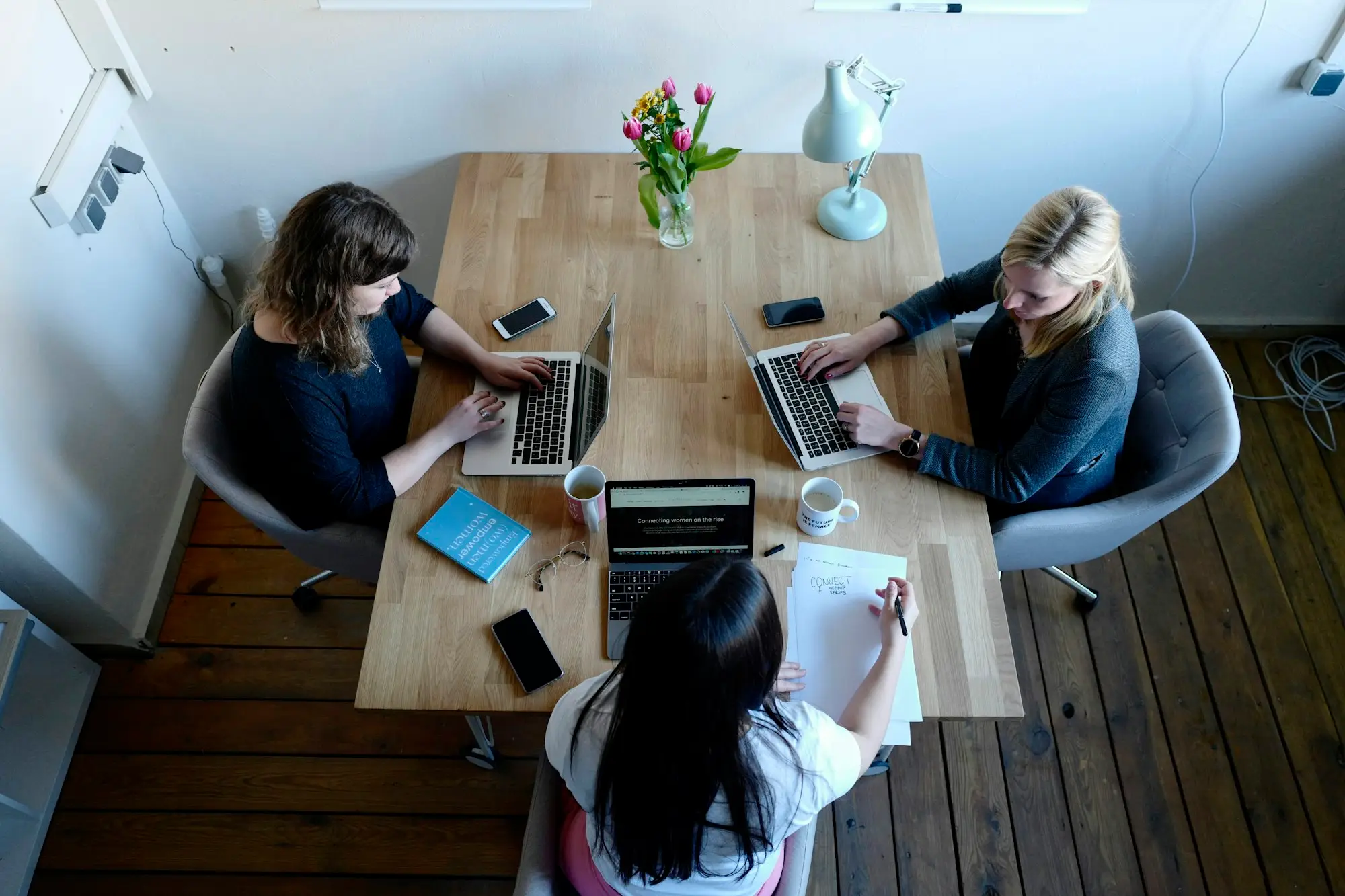 Family business owners planning around a kitchen table with a notebook and laptop