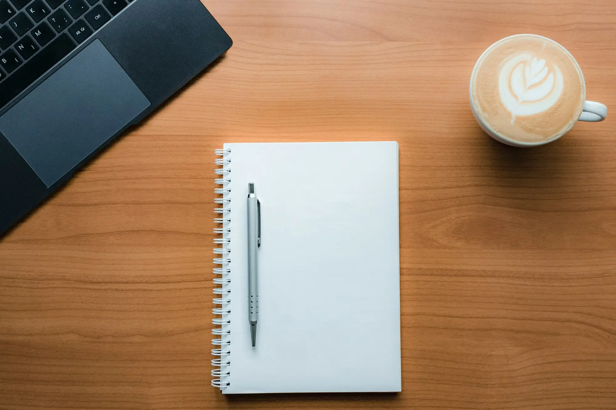 Notebook with a handwritten numbered list next to a coffee cup on a café table