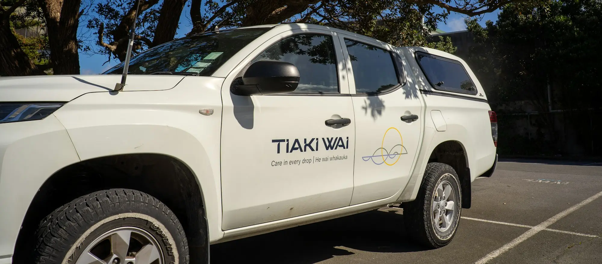 Tradesperson loading tools into the tray of a ute on a suburban Brisbane street