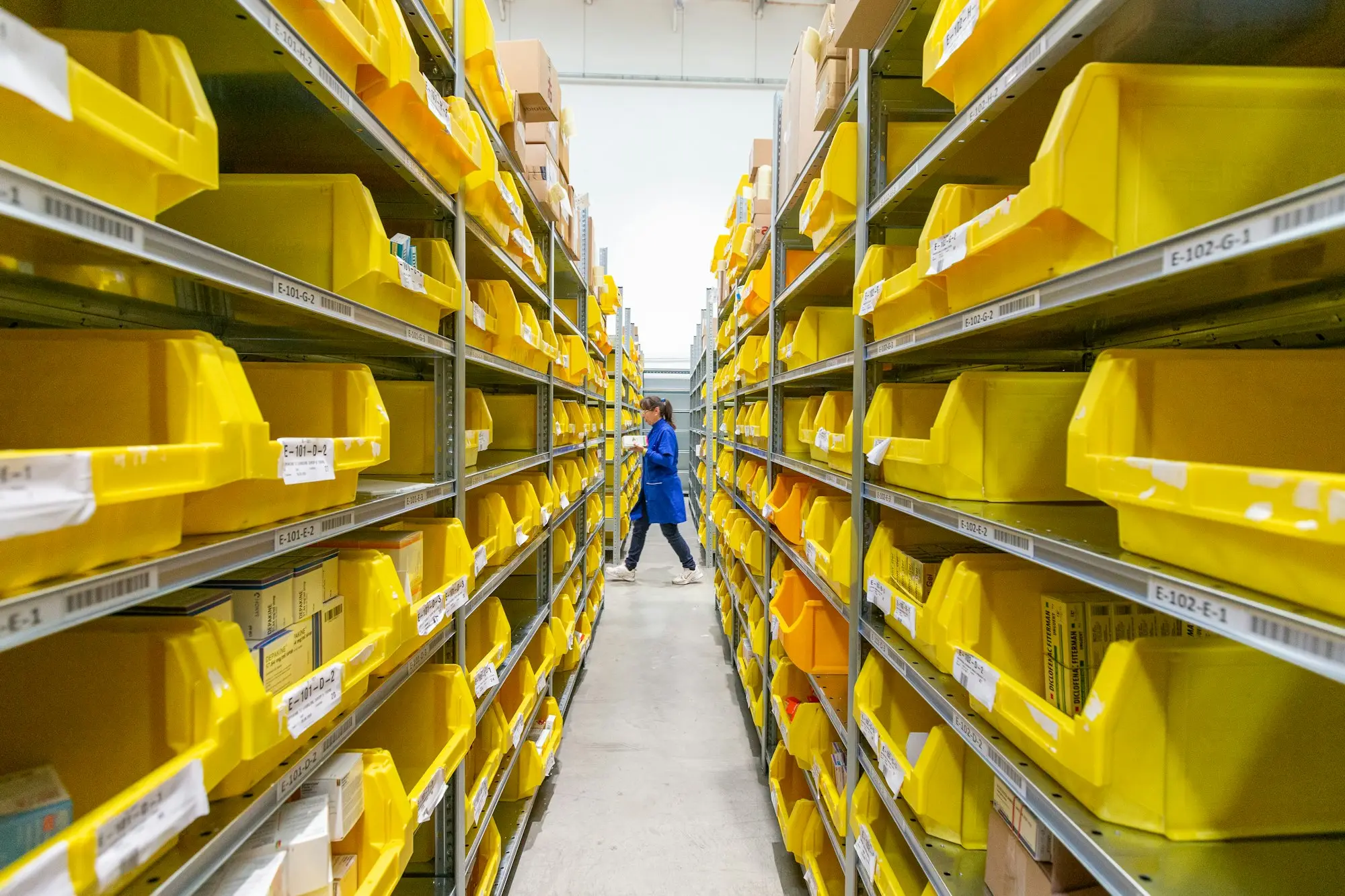 Warehouse worker checking boxed stock on tall shelves in a Sydney distribution warehouse